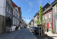 Das Bild zeigt die Marktstraße in Wipperfürth. Zwischen den Häusern sind weiß/rote Wimpelketten gespannt.
