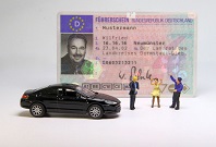 Das Bild zeigt einen Führerschein und ein Auto. 